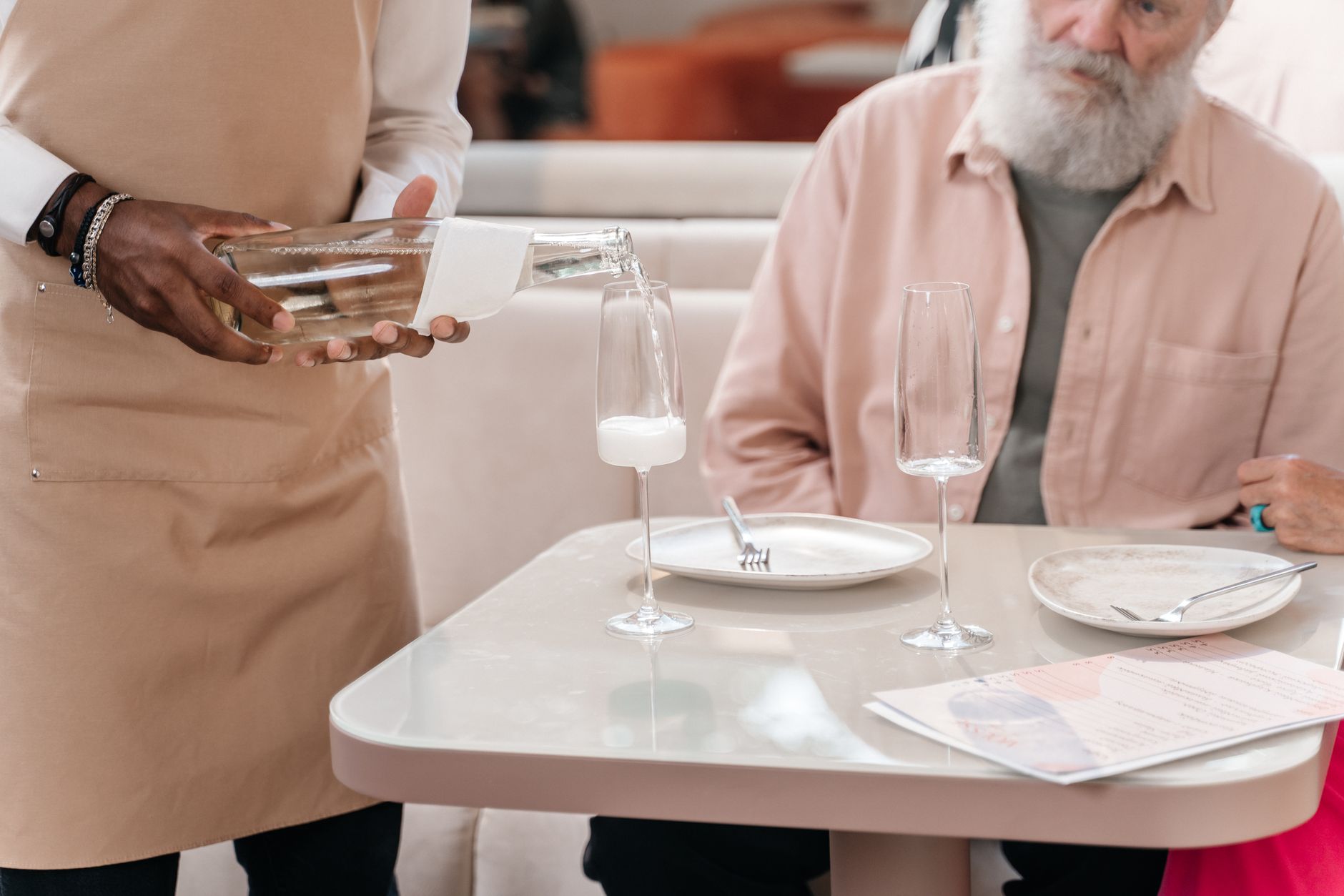 Kellner bedient Gäste eines Restaurants professionell