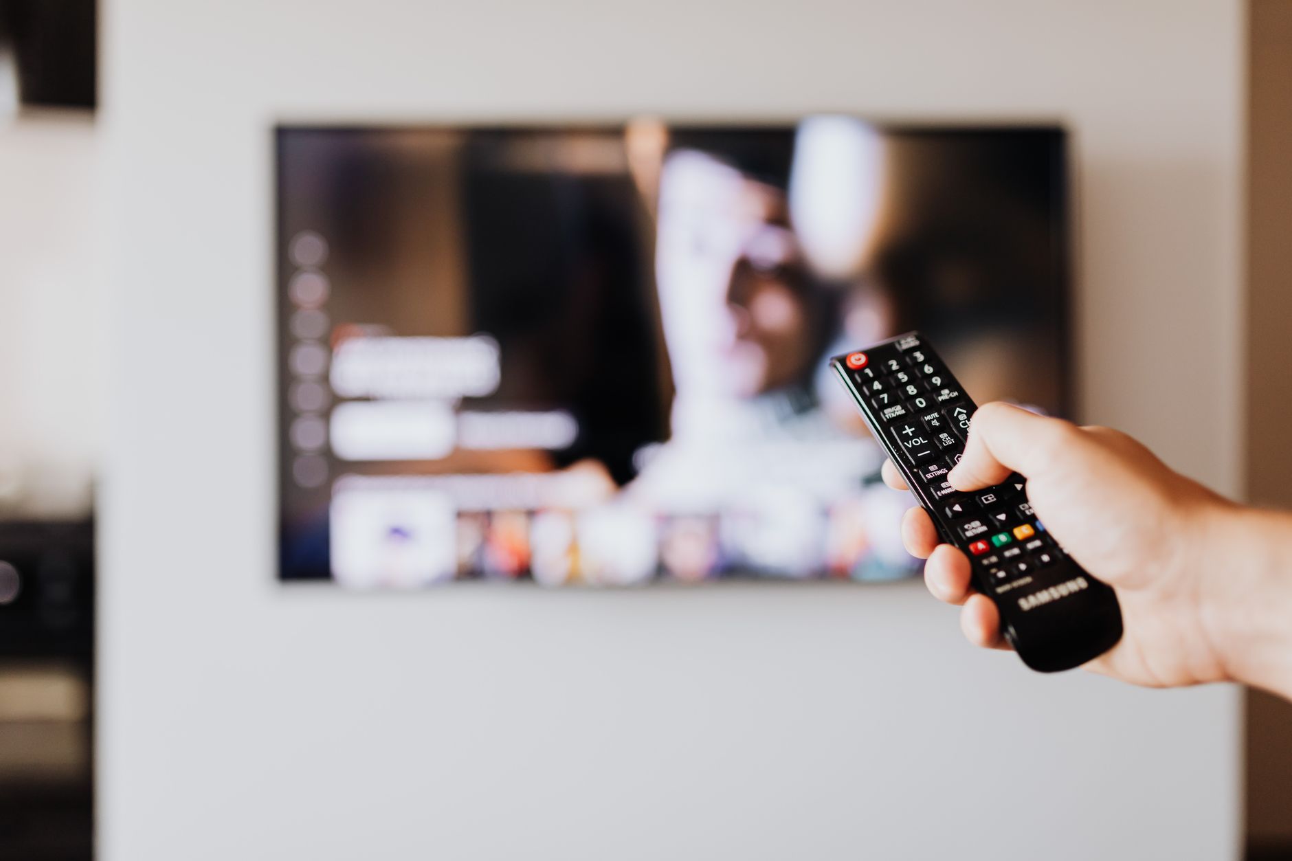 Familie schaut gemeinsam Streaming-Inhalte auf einem Smart TV mit Fernbedienung