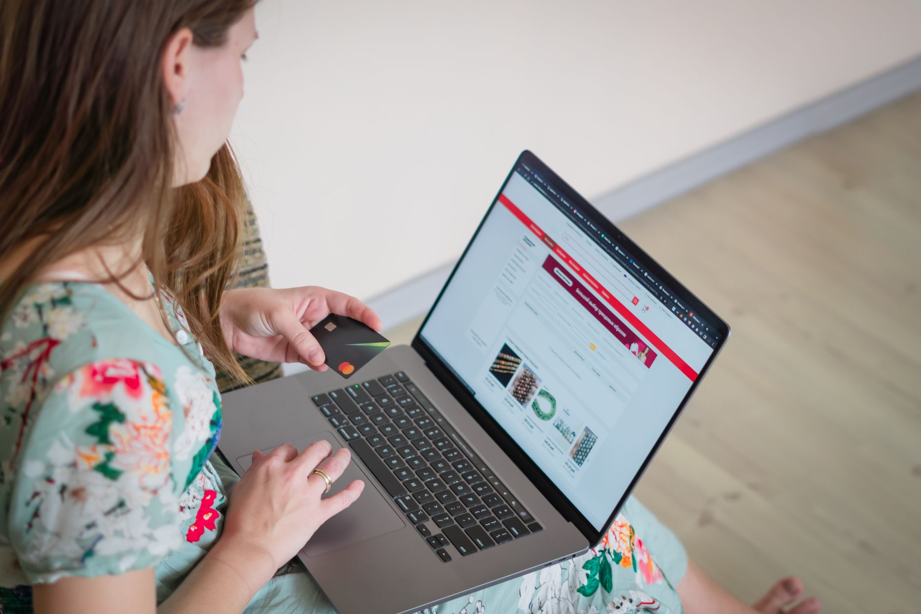 Person shopping online and paying with a card on a laptop