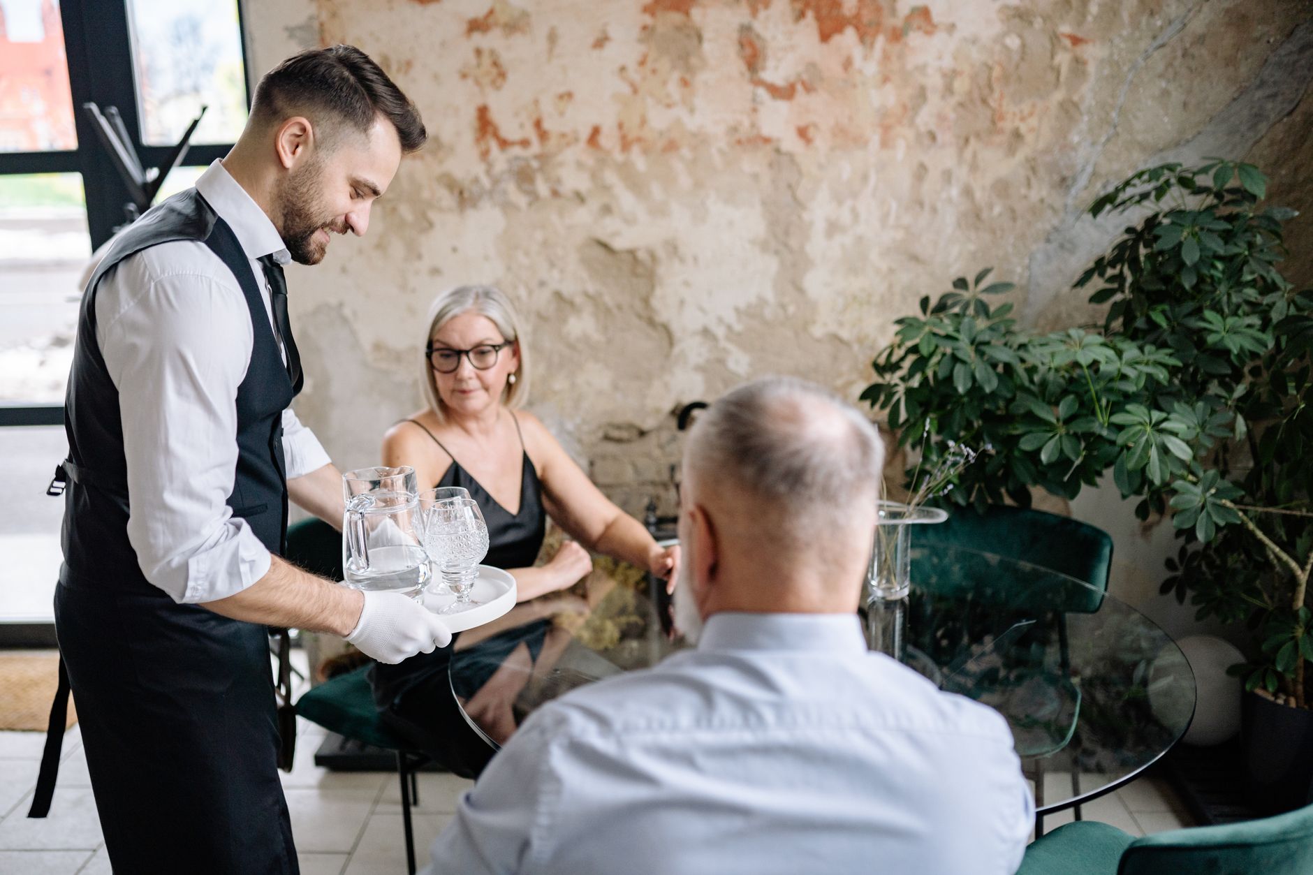 Waiter attentively serving guests at a restaurant table