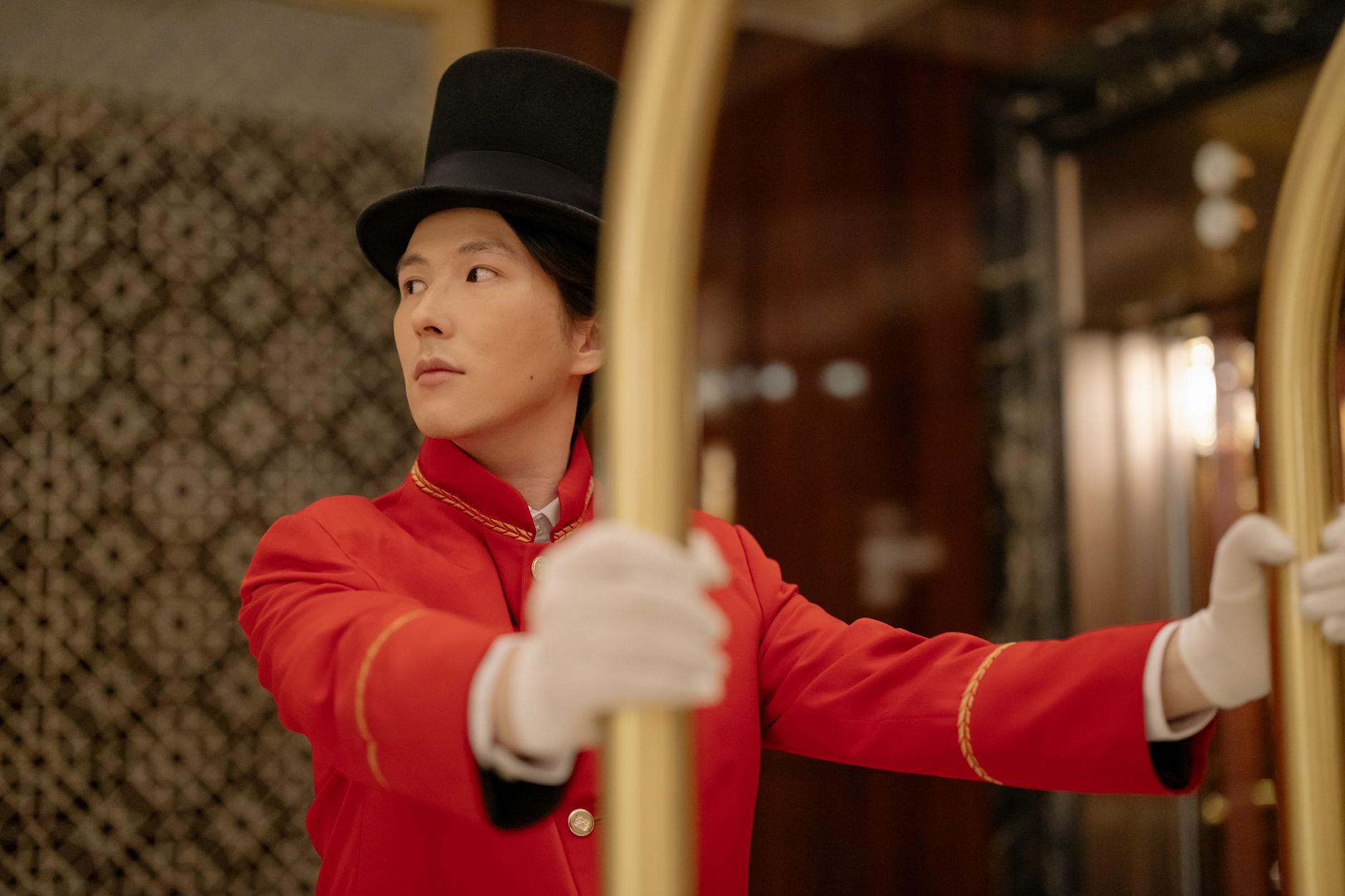 Hotel bellboy assisting a guest with luggage in the lobby