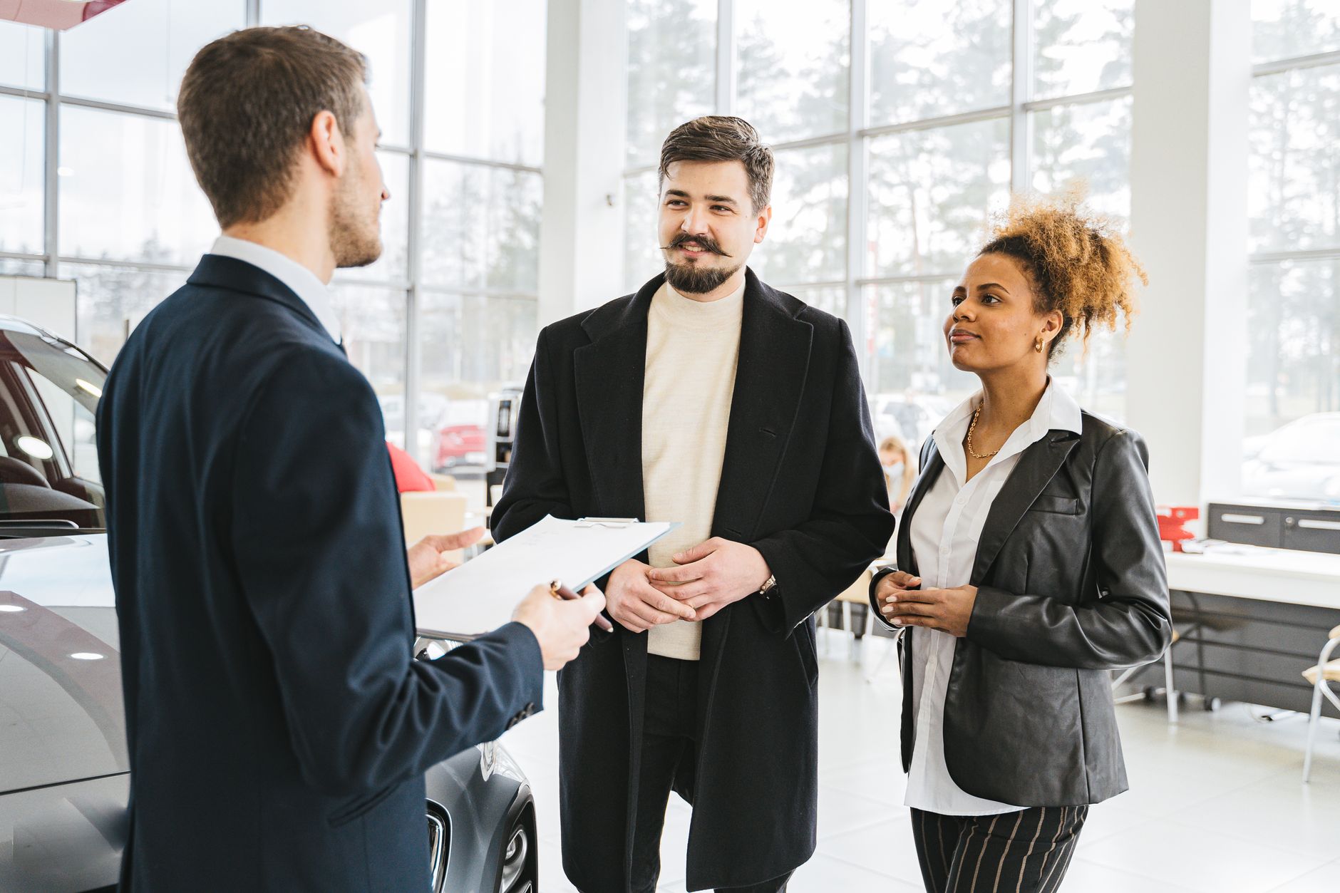 Commercial automobile et client lors d'une présentation de véhicule en concession