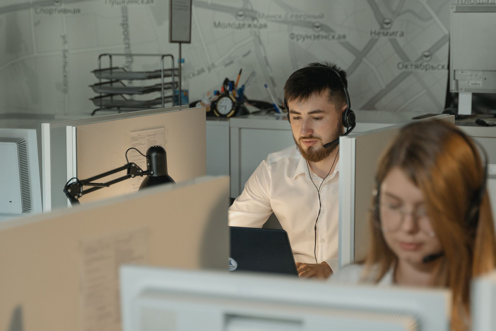 Agente de soporte tecnico con auriculares atendiendo a un cliente en la oficina