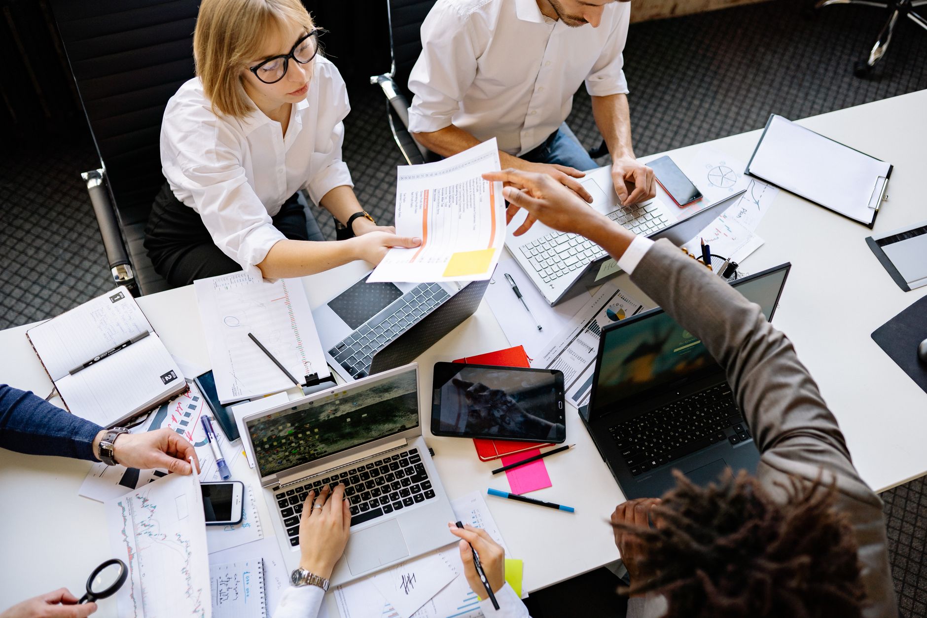 Equipo de startup trabajando en ordenadores portátiles en oficina moderna