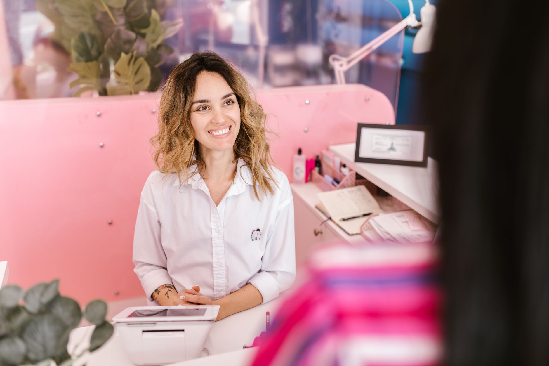 Recepcionista de gimnasio dando la bienvenida a un socio potencial durante una auditoría mystery shopper
