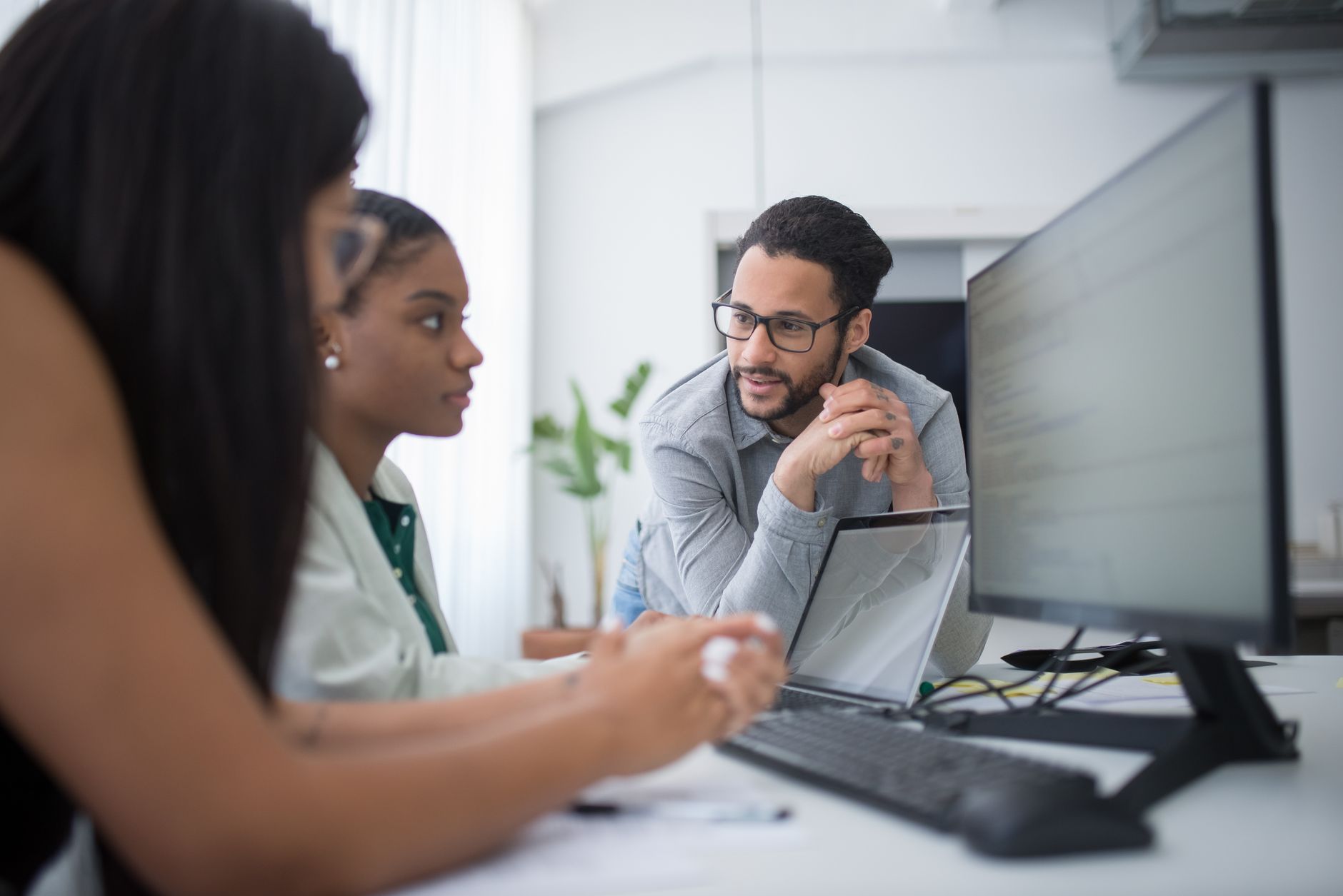 Equipo de una pyme en una reunion revisando el CRM y el software de gestion en un portatil