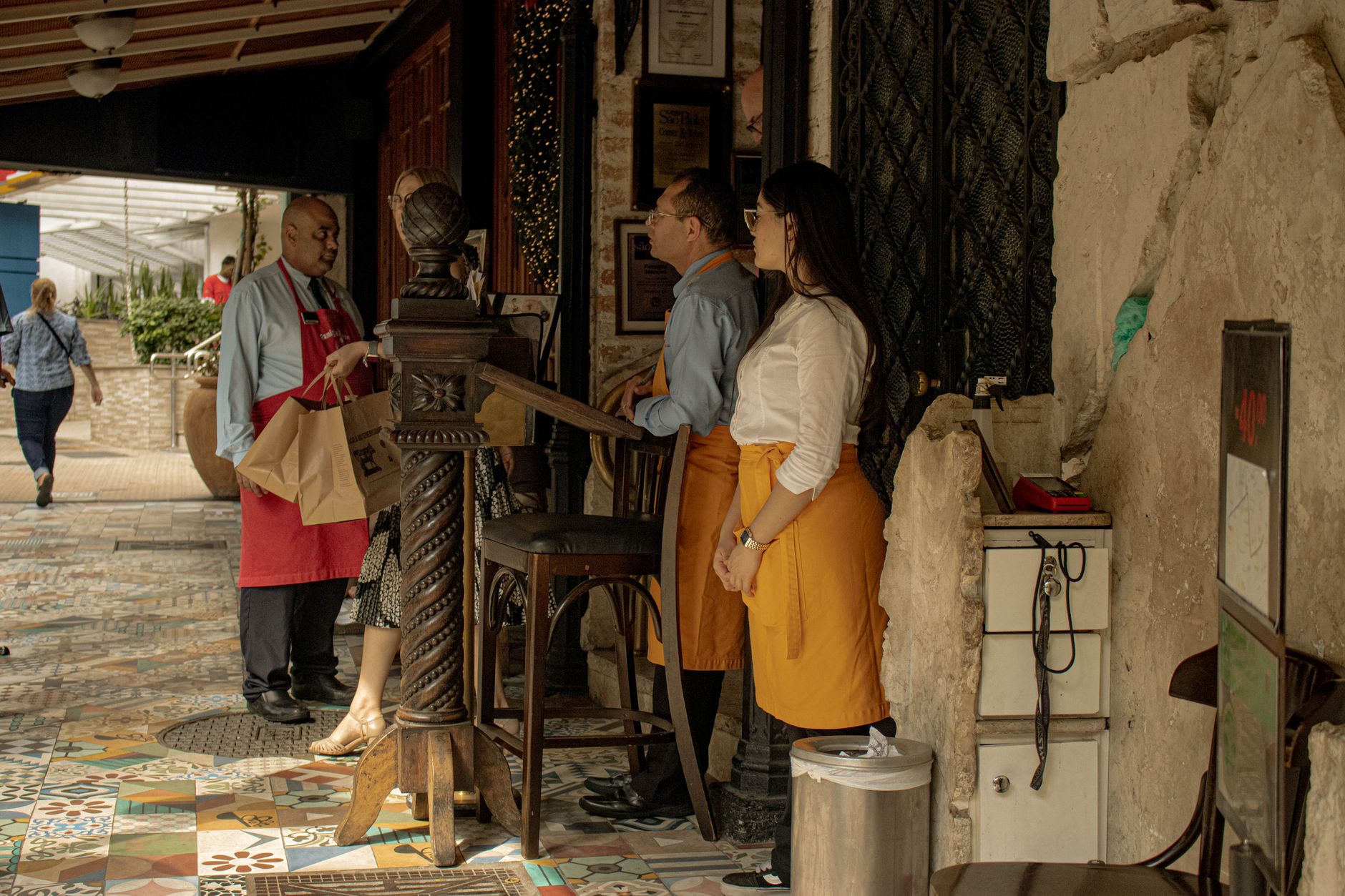 Camarero recibiendo y dando la bienvenida a un comensal en la entrada de un restaurante