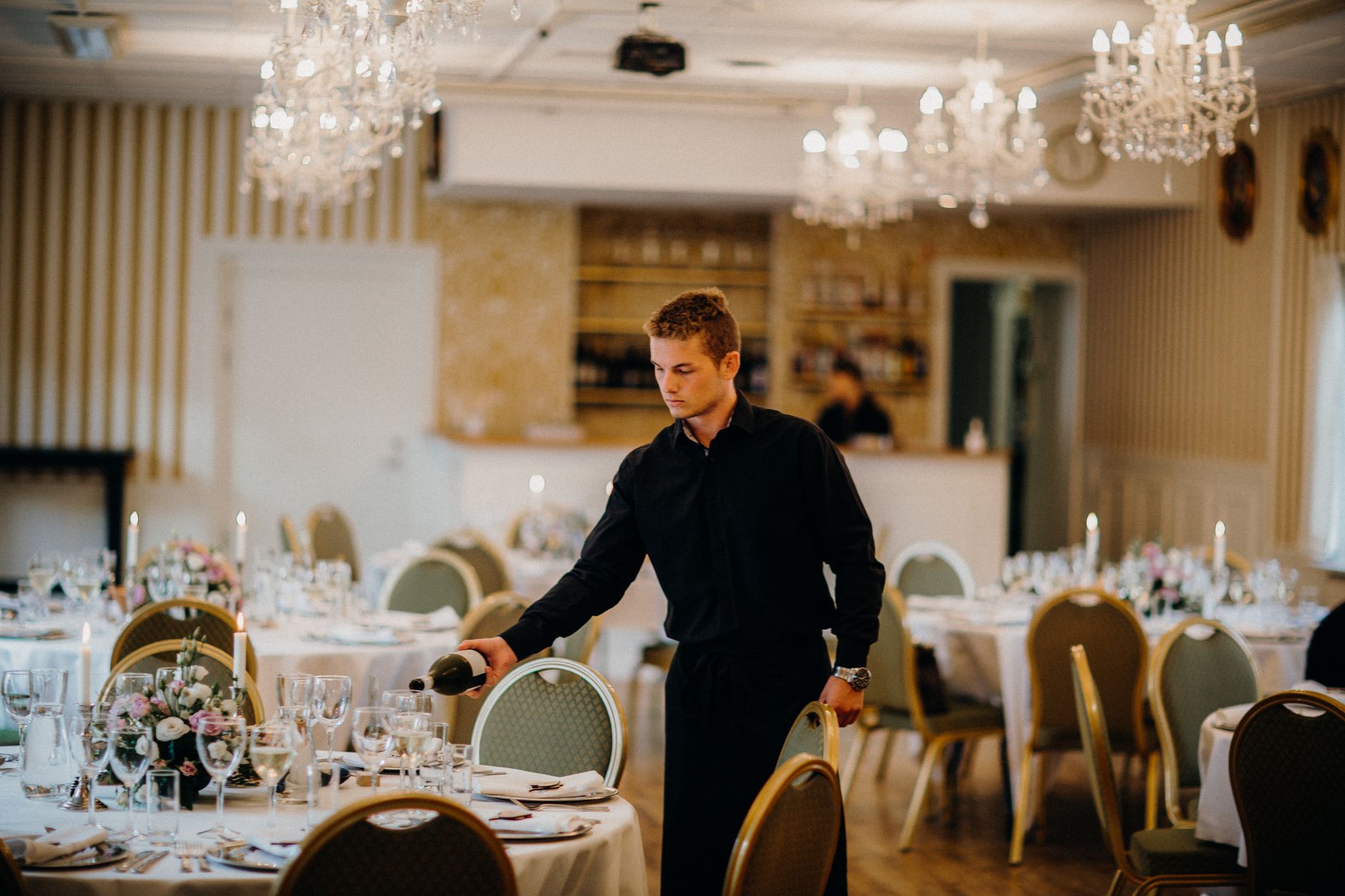Camarero preparando mesas y contabilizando comensales para un banquete de restaurante