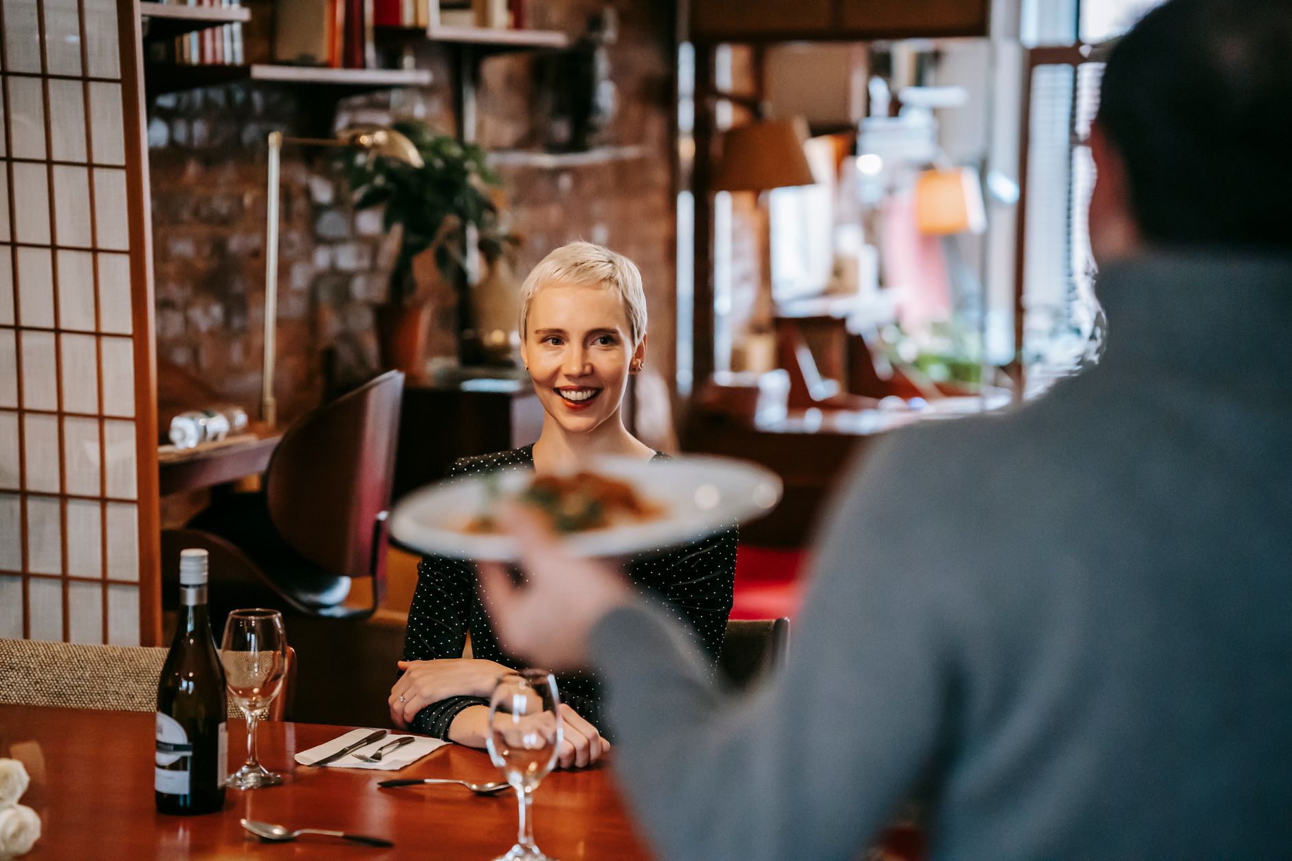 Camarero atendiendo a una pareja en una cena romántica de restaurante