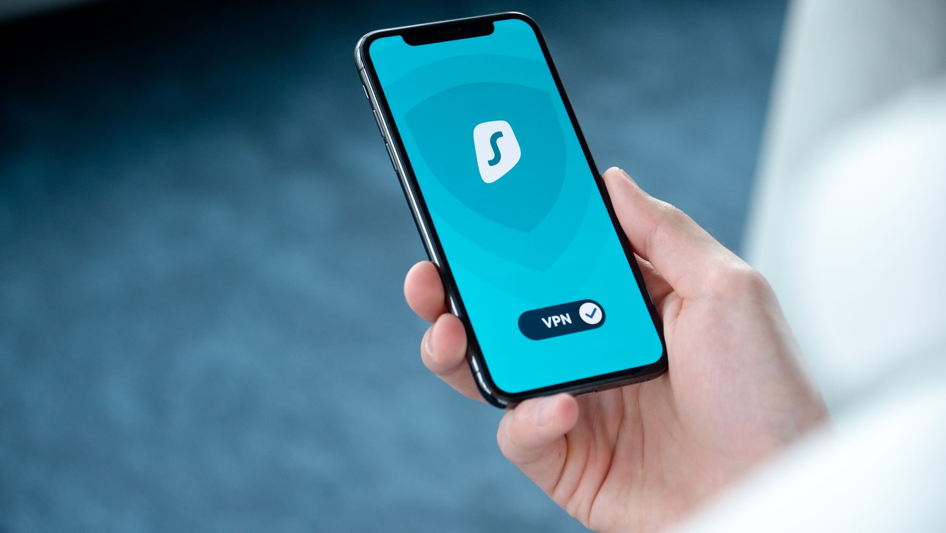 Mano sosteniendo un telefono movil con un icono de privacidad y seguridad digital en pantalla